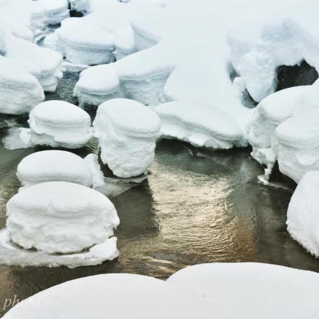 川の岩に積もる雪